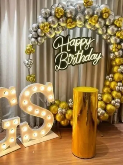 This is another angle of the personalized 'GS' birthday setup. The combination of the metallic balloon ring and the warm marquee letters creates a very celebratory and photogenic corner.