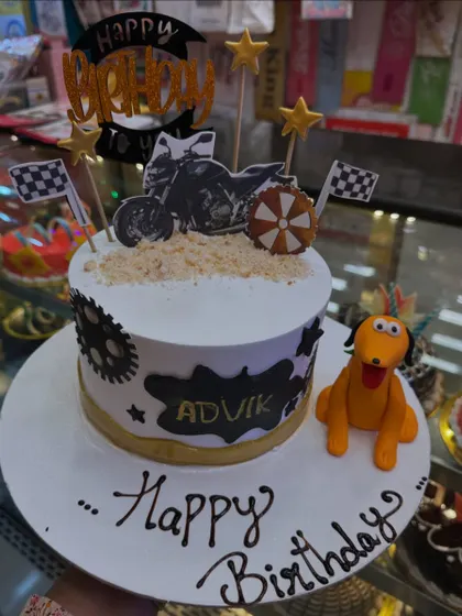 A cool bike-themed cake for a birthday celebration. It features a bike topper, gear details, and even a cute fondant dog, showing how I can combine multiple interests into one design.