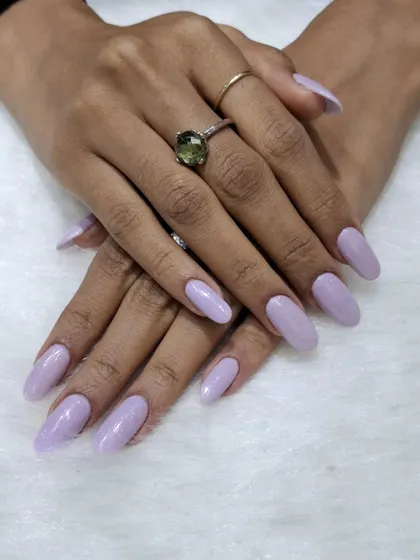 A simple and serene look featuring a solid soft lavender color on medium-length almond nails. This pastel shade is chic, calming, and effortlessly stylish.
