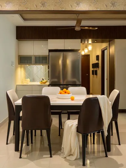 The renovated dining area in 'Blue Elegance' with a new crockery unit that seamlessly integrates the existing refrigerator. The fluted panels above cleverly conceal the loft storage.