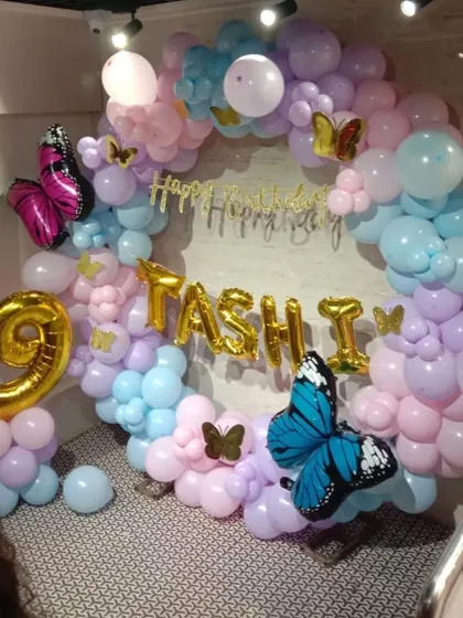 A full view of the enchanting butterfly-themed 9th birthday. The pastel balloon ring, personalized details, and large, colorful butterflies create a stunning centerpiece for the party.