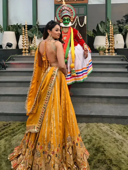 A vibrant yellow lehenga for an event in Ludhiana, posing with a traditional Kathakali dancer. I love when events celebrate the rich culture of India.
