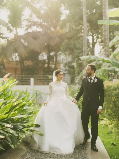 A romantic portrait of the couple in a lush, green garden. The natural light and beautiful surroundings create a serene and intimate atmosphere.