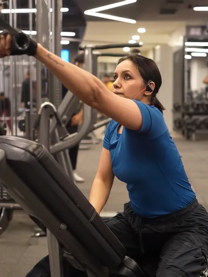 Using the cable machine for a single-arm pulldown, this client is isolating her back muscles for targeted strength and development.