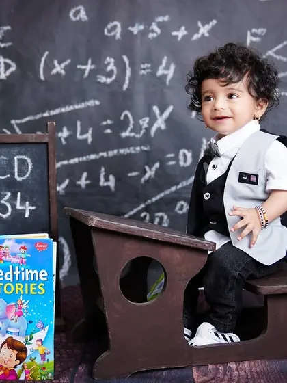 A wider shot of the "back to school" themed first birthday, showing the adorable little boy at his desk.