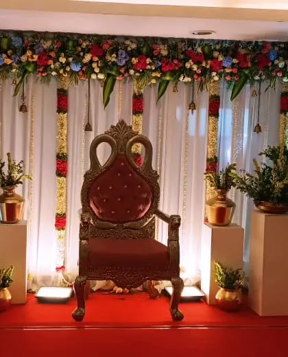 A coustamised floral decoration for a Seemantham or baby shower. We used a traditional red throne chair, banana leaf props, and beautiful floral arrangements to create an authentic and festive look.