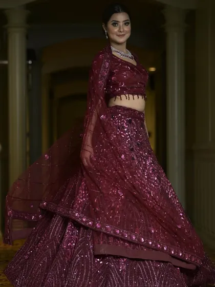 A full-length view of our wine-colored sequin lehenga. The rich color and all-over sparkle make it a glamorous and sophisticated choice for an evening reception or cocktail party.