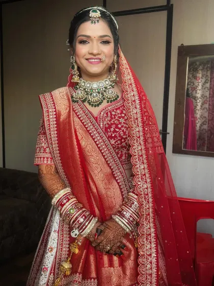 A beautiful portrait of the bride ready for her pheras. The makeup highlights her features with a soft glow, perfectly matching her red and white lehenga.