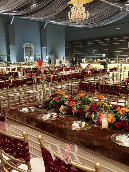 A wide view of the dining hall, showing how the long tables with their vibrant floral runners create powerful lines and draw the eye through the space.