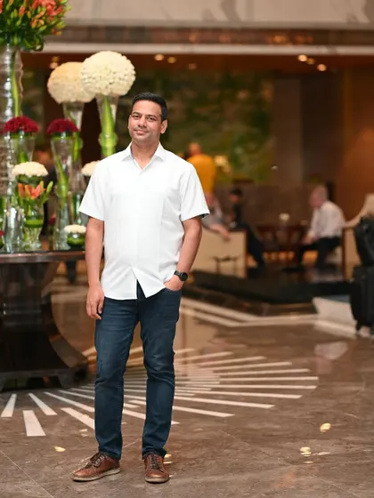 A full-length portrait in a grand hotel lobby. This environmental shot adds a touch of class and worldliness to a matrimonial profile.