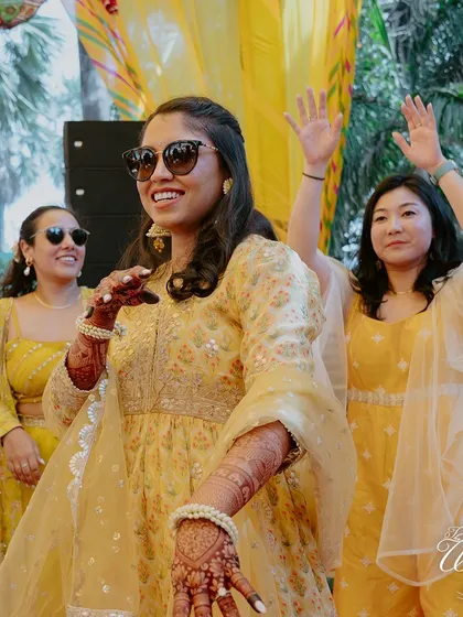 The bride, looking chic in sunglasses, enjoying the dance party at her Haldi.