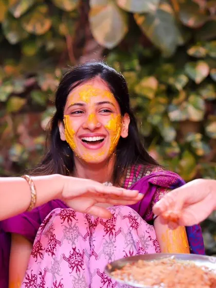 Contagious laughter at the Haldi ceremony. The bride's joyful expression is the centerpiece of this vibrant, happy photo with her loved ones.