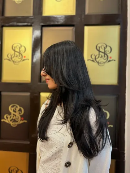 A profile shot that really shows off the perfect layers and face-framing curtain bangs. This haircut adds so much texture and movement.
