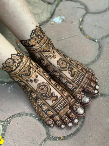 Bridal mehendi isn't complete without adorning the feet. This design features detailed paisley and traditional motifs, creating an elegant look that complements the bride's attire.