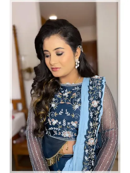 A closer look at this sangeet glam. The hairstyle features soft waves pulled back with a delicate accessory, perfectly complementing the soft yet defined eye makeup.
