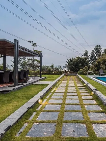 The landscaped pathway connecting the swimming pool and outdoor pavilion, designed with integrated lighting for ambiance and functionality.