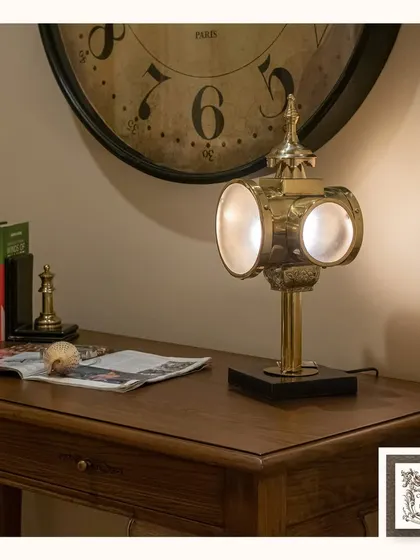 This vintage-style desk lamp, inspired by old carriage lights, adds a classic and functional touch to a study. Its brass finish and unique design make it a true conversation starter.