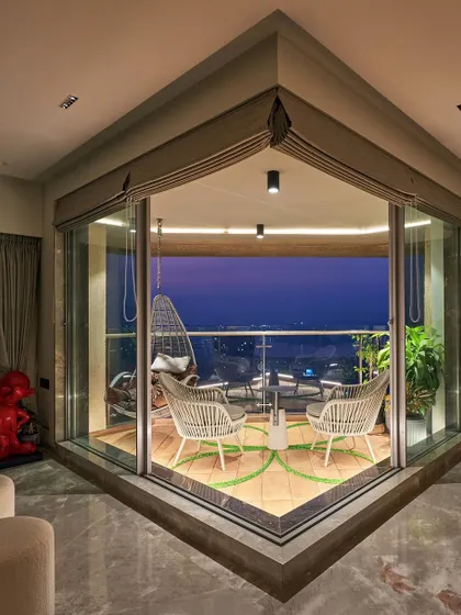 This corner balcony is designed to be a peaceful escape overlooking the Mumbai skyline. We selected comfortable all-weather seating and a hanging swing chair to create the perfect spot to unwind and enjoy the city view at dusk.