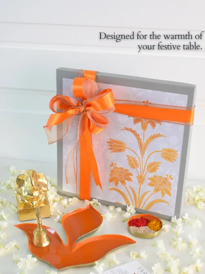 Designed for the warmth of your festive table. This beautifully wrapped gift box, featuring our orange Pushpa tray, is a perfect example of our thoughtful festive hampers.