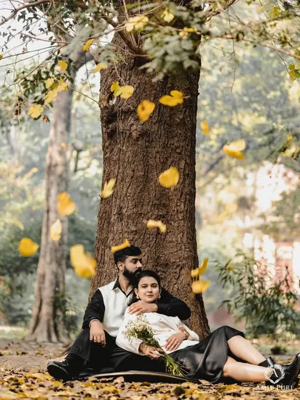 A quiet moment of togetherness under a canopy of falling autumn leaves. This image captures the soft, poetic side of romance, perfect for couples who love a simple, nature-inspired vintage aesthetic.