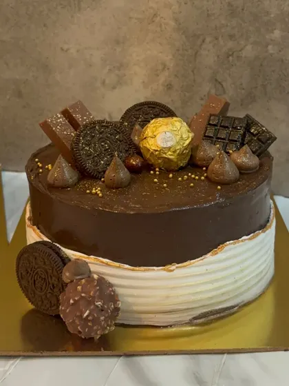 A half and half cake design, with one side featuring a clean, textured white buttercream and the other a rich chocolate topping with Ferrero Rocher and Oreos.