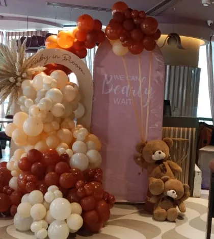 This shows a full restaurant space decorated for a baby shower with a rustic teddy bear theme. I used balloons in burnt orange, brown, and beige to create a main backdrop and smaller arrangements for the tables.
