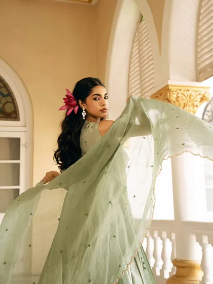 A beautiful shot capturing the movement of the dupatta. The soft light and the model's expression create a dreamy and romantic mood.