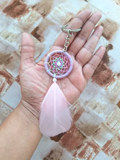 A dreamy pastel rainbow dreamcatcher keychain with a soft pink feather. This is the ultimate bag bling for the free-spirited.