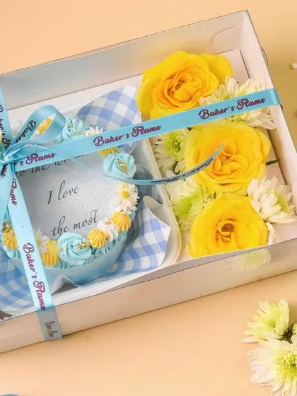 A bakery hamper featuring a horseshoe-shaped cake and fresh yellow roses. The combination of food and flowers creates a beautiful and celebratory gift image.