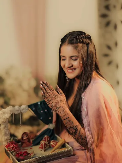 A bride looking at her hands during her mehandi ceremony. It's a moment of quiet joy and anticipation.