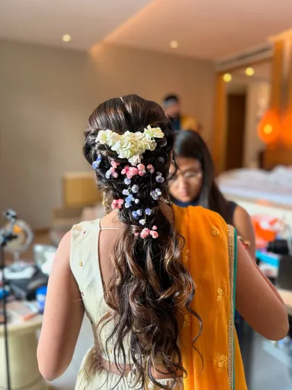 A close-up of the pastel floral braid from the beach wedding, showing the soft waves and the delicate mix of pink, blue, and white flowers.