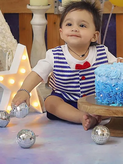 A close-up of this charming birthday boy, with his sweet smile and a beautifully decorated blue ombre cake.