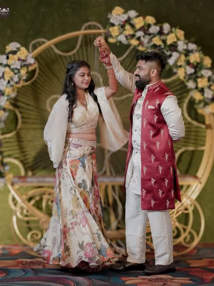 A joyful moment from a Sangeet or reception, where the groom twirls the bride under the lights of the decorated stage. This candid shot captures the fun and movement of wedding celebrations.