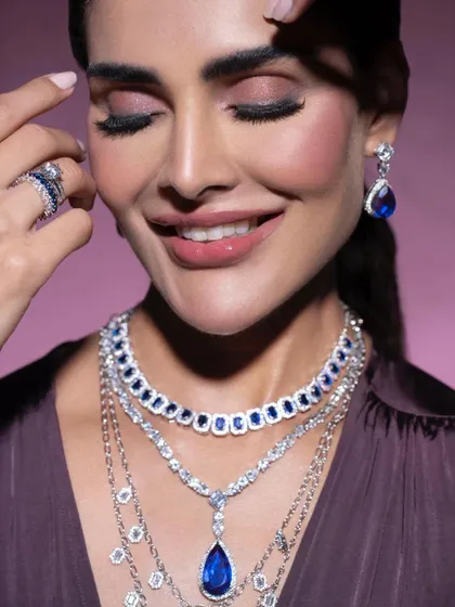 A happy, smiling shot that brings a sense of warmth and accessibility to luxury jewelry. It shows that high-end pieces can be styled in a way that feels personal and joyful.