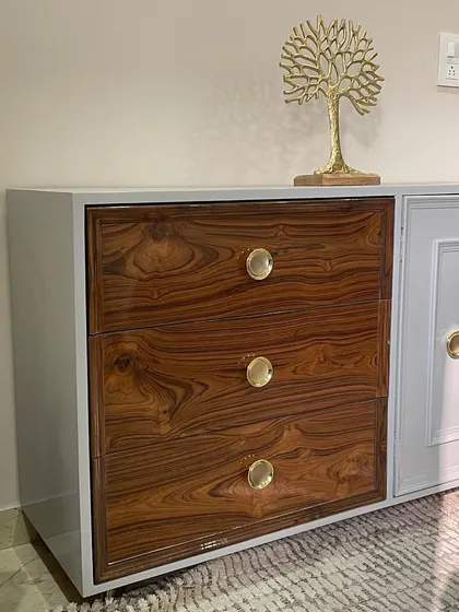 A custom-designed storage cabinet perfect for a home office or entryway. This piece features a unique combination of a natural wood-grain drawer unit and a white panelled cabinet, all in one sleek frame.