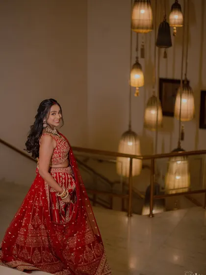 A beautiful shot of the bride on a staircase, with warm, hanging lights creating a dreamy background.