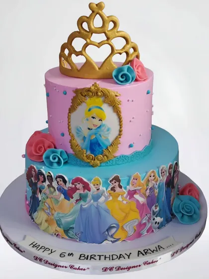 A two-tier Disney princess cake featuring Cinderella and an array of other beloved princesses. This whipped cream cake is decorated with a golden tiara and edible images for a magical 6th birthday.