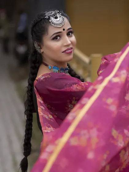 A lovely candid-style shot that captures the essence of this fusion look. The side-swept braid and statement maang tikka create a youthful and trendy vibe.