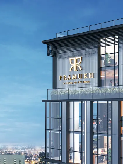 The top of the "Pramukh" commercial tower in Surat. The branding is integrated into the architecture, which is defined by a clean, modern, and minimalist design language suitable for a corporate landmark.