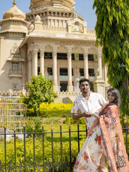 A pre-wedding photo taken in front of a historic building, adding a touch of grandeur and local flavor to the couple's album.