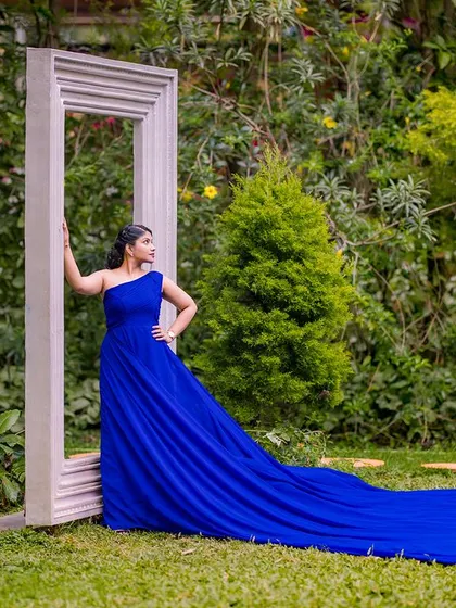 A high-fashion pose with the giant frame props. The royal blue gown with its extra-long train creates a stunning visual that stretches across the entire frame.