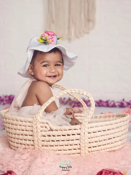 A sweet girl in a wicker basket, surrounded by a field of flowers. This shows how we use different props and textures to create beautiful scenes.