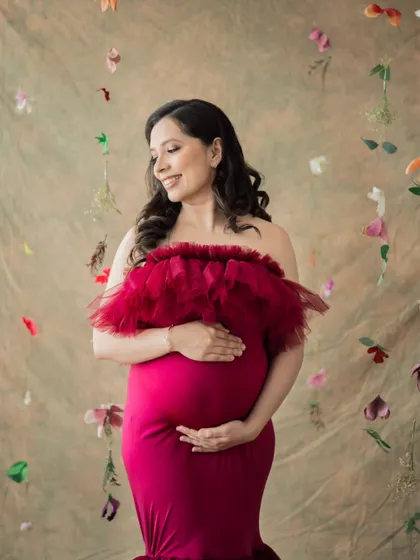 A solo portrait of a mother-to-be, surrounded by a cascade of delicate flowers. This setup adds a touch of whimsy and beauty to the maternity session.
