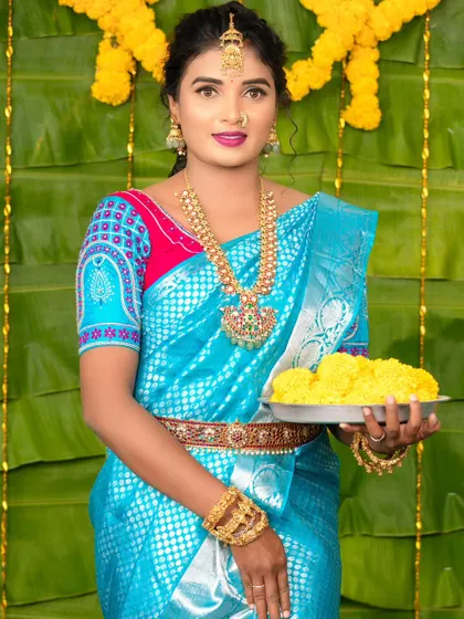 A festive shot of the model holding a plate of flowers, her traditional jewellery shining.
