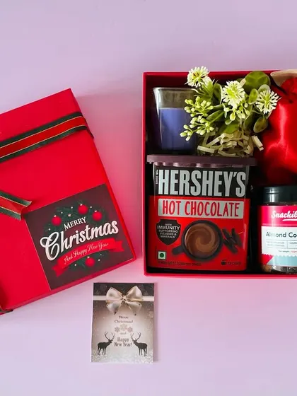 Inside our Christmas hamper, you'll find cozy treats like Hershey's Hot Chocolate, almond cookies, and a scented candle.