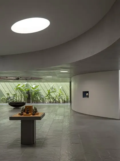 The interior of the Vismaya museum is a fluid, open-plan space modulated by curving walls and carefully controlled light from above. This allows for a flexible arrangement of artifacts and creates a varied journey for the visitor.