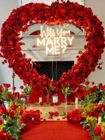 This is the ultimate fairytale proposal setup. I used a heart-shaped arch made entirely of red roses, a custom "Will You Marry Me?" neon sign, and a petal-strewn path to create a truly unforgettable moment.