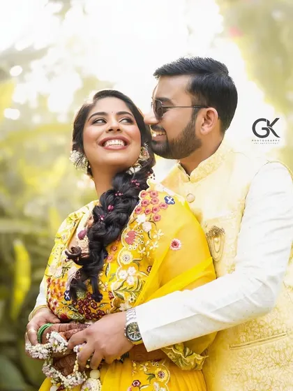 A happy couple enjoying their Haldi ceremony. The bride is wearing a beautiful yellow lehenga with our custom fresh flower jewellery.