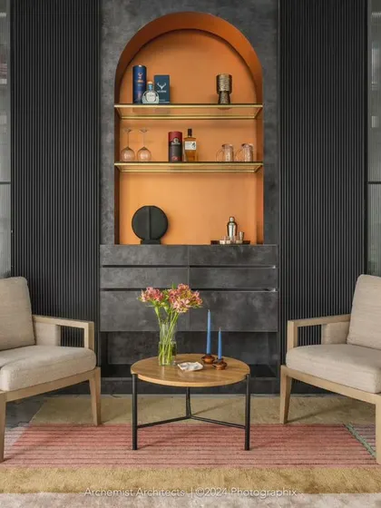 The lounge area by the terrace features a bold, custom bar cabinet in black and gold. We furnished the space with simple, comfortable, and structured lounge chairs to create a sophisticated mood.