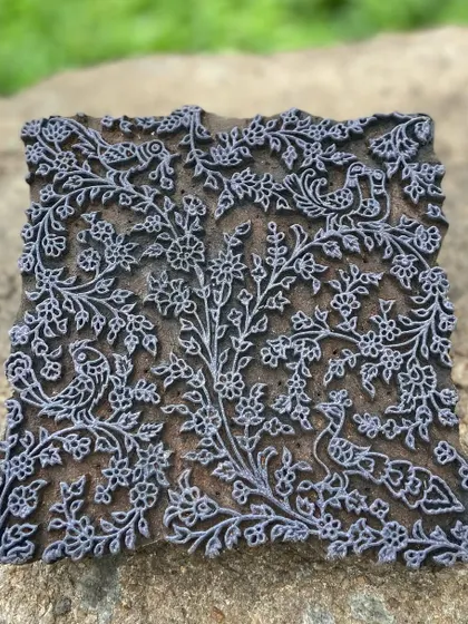 This vintage 'tree of life' block is a treasured piece from our archive. Intricately carved with birds and flowers, it represents the deep connection to nature and heritage that we weave into every fabric we produce.